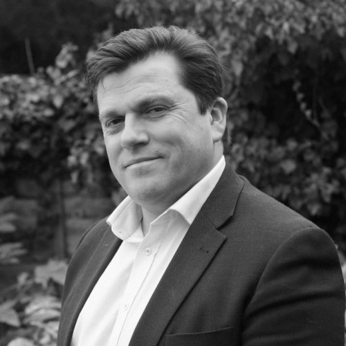 Hypnotherapist in Chester and Colwyn Bay Paul Russell profile photo in black and white in smart suit