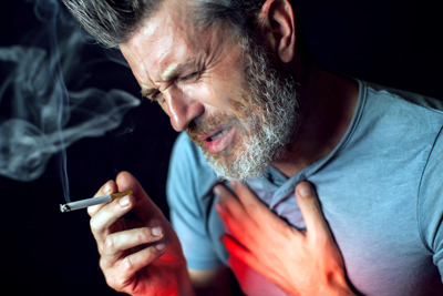 Hypnotherapist in Chester and Colwyn Bay man smoking clutching chest with red physical pain