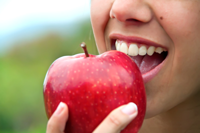 Hypnotherapist in Chester and Colwyn Bay woman biting big red shiny apple